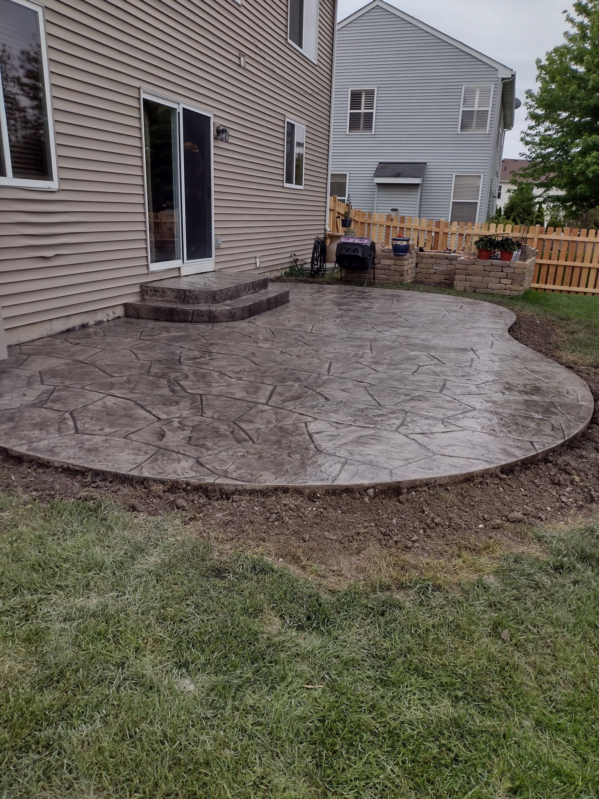 There is a patio in the backyard of a house.