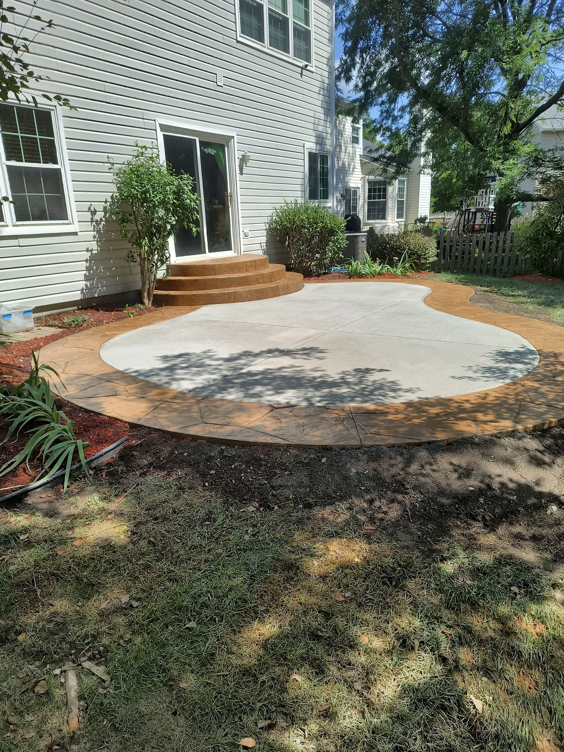 There is a patio in the backyard of a house.
