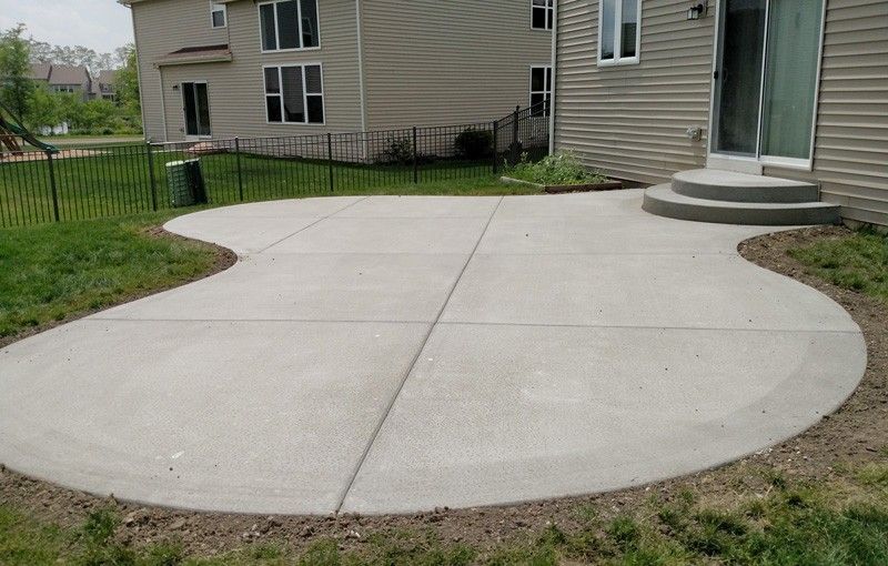 A curved concrete patio in front of a house.