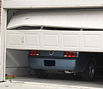 A car is parked in a garage with the door open