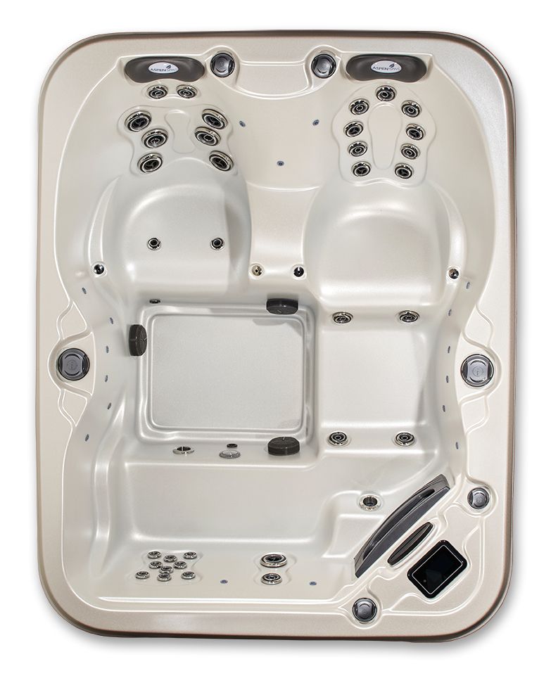 A top-down view of an empty, light-colored hot tub with multiple molded seats and various water jets.