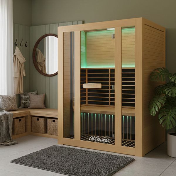 A light-wood indoor sauna with glass doors, glowing green LED lights, and a bench, placed in a modern room with a rug.