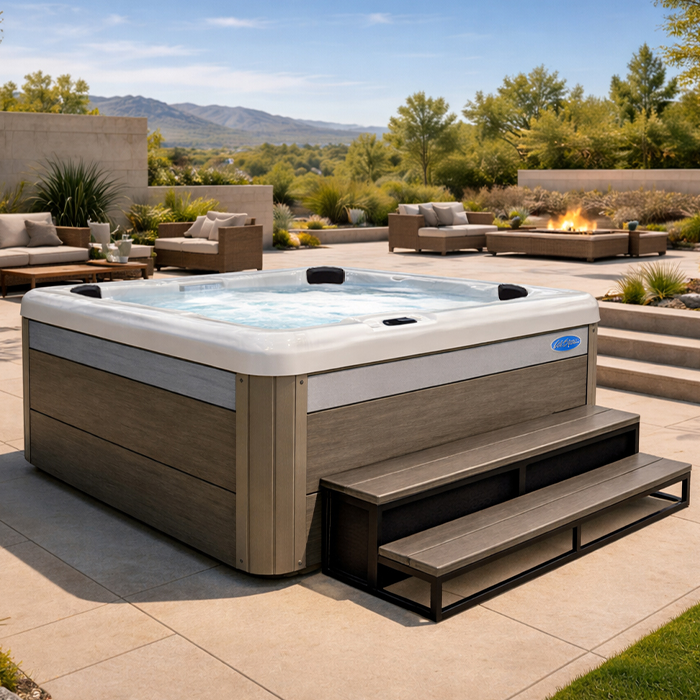Modern backyard with a wood-paneled hot tub, built-in steps, and desert landscaping under a sunny sky