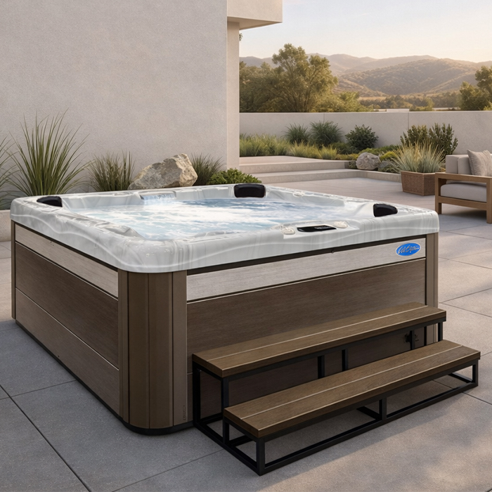 Outdoor hot tub with steps on a patio, set against a desert hillside backdrop