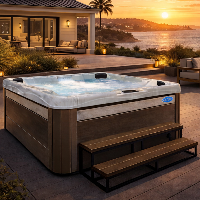 Backyard hot tub on a deck beside a modern home at sunset, overlooking the ocean