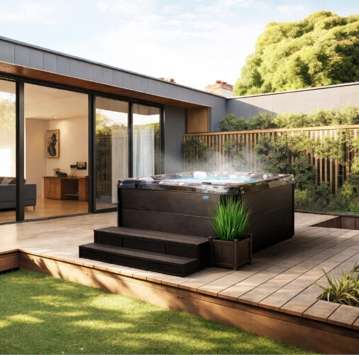 Modern backyard patio with a built-in hot tub beside sliding glass doors and a lawn