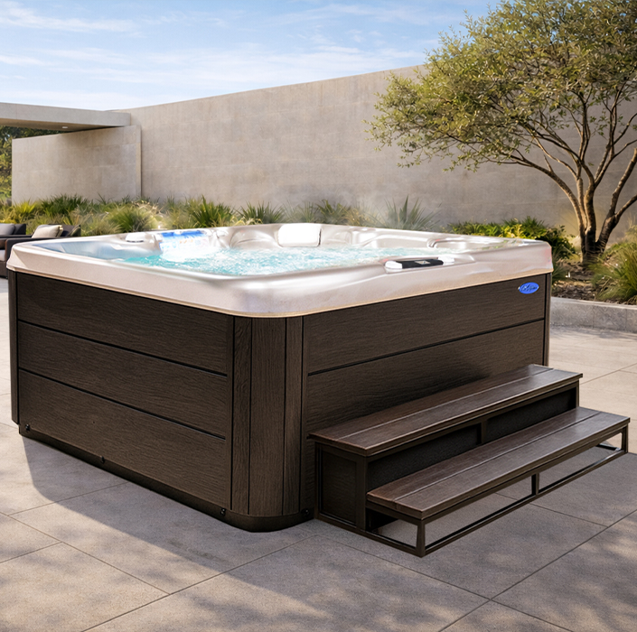 Dark wooden hot tub with steps on a sunny patio in a desert-style yard