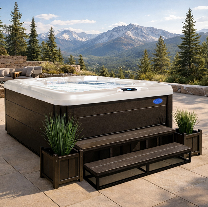 Outdoor hot tub on a stone patio with mountain and pine forest views