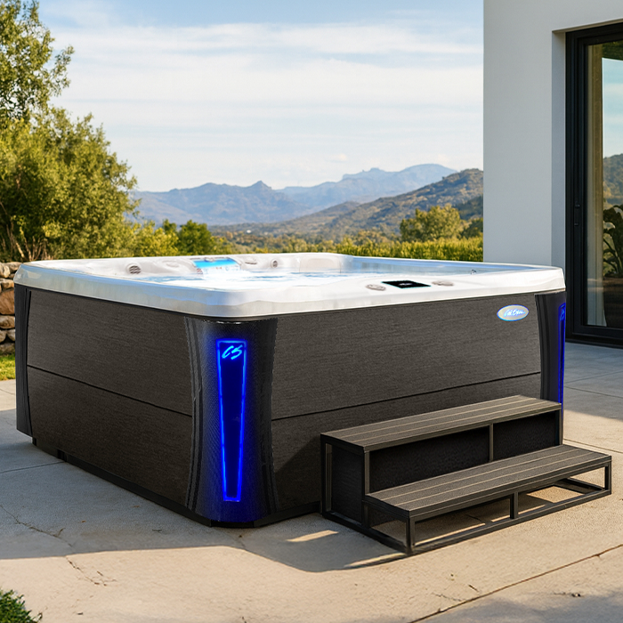 Modern black hot tub with blue LED light on a patio overlooking mountains