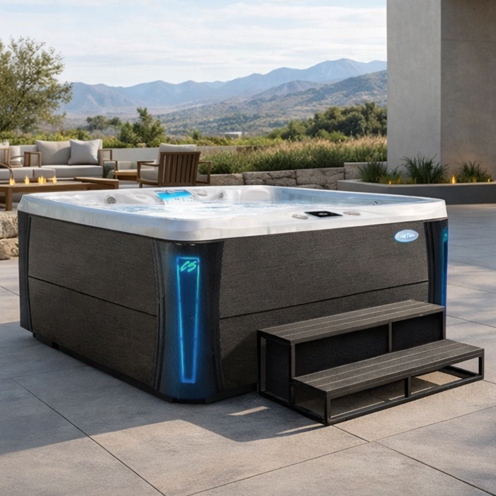 Modern outdoor hot tub on a patio, with blue-lit corners and mountain views in the background