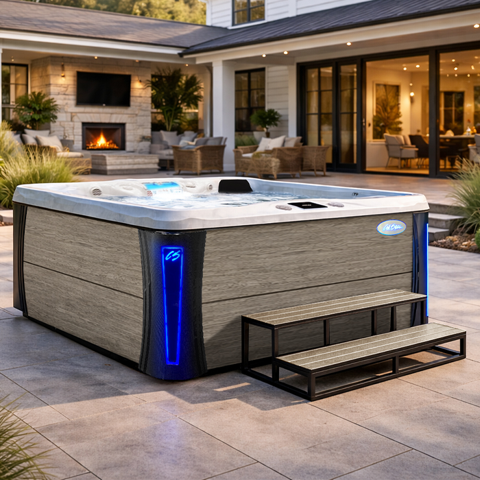 Modern outdoor hot tub with blue lights on a patio in a backyard living space