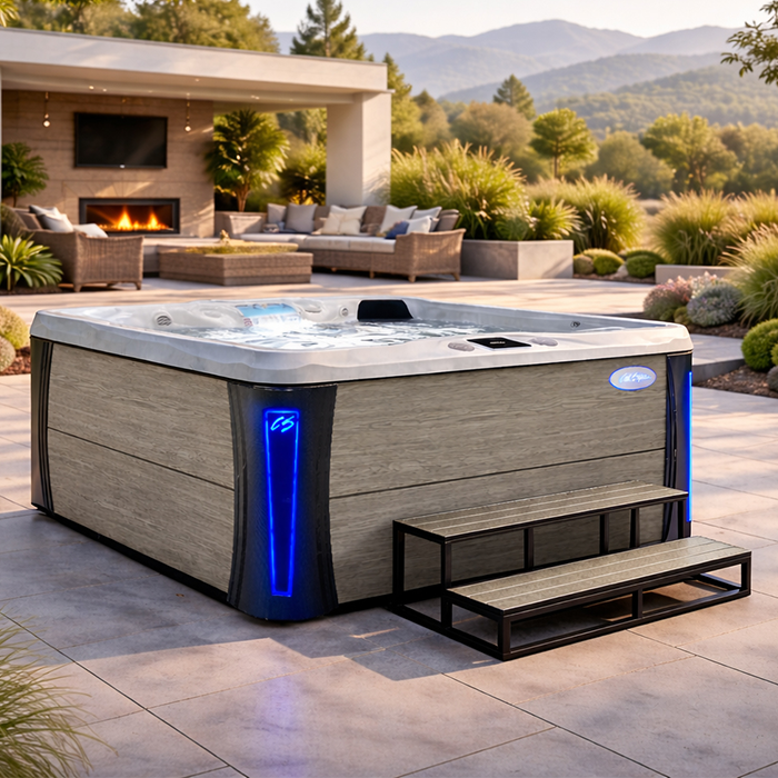 Modern backyard patio with a large blue-lit hot tub beside lounge seating and desert landscaping