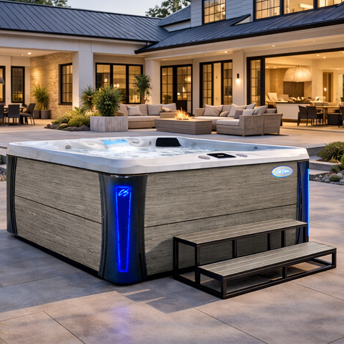 Modern backyard with a large wood-paneled hot tub and blue LED light beside an outdoor patio seating area