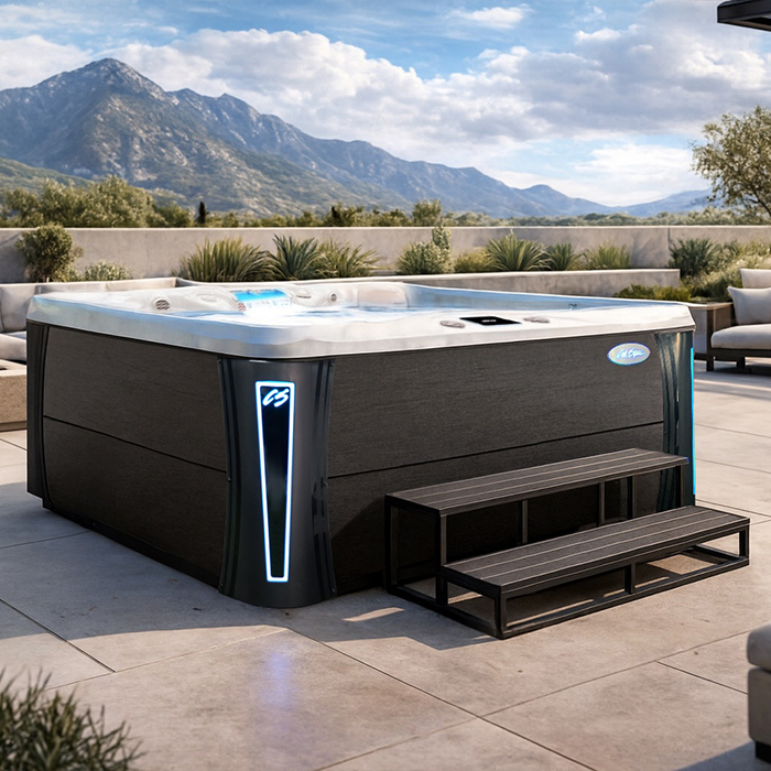 Modern outdoor hot tub with dark wood paneling and lit corner, set on a patio with mountain view
