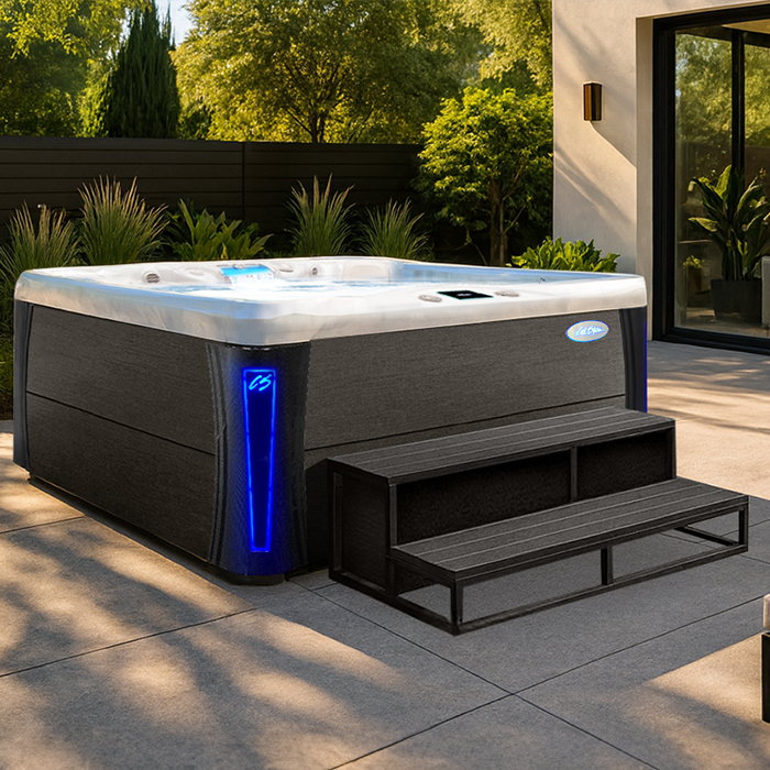 Modern outdoor hot tub with blue accent lights and steps on a patio in a landscaped backyard