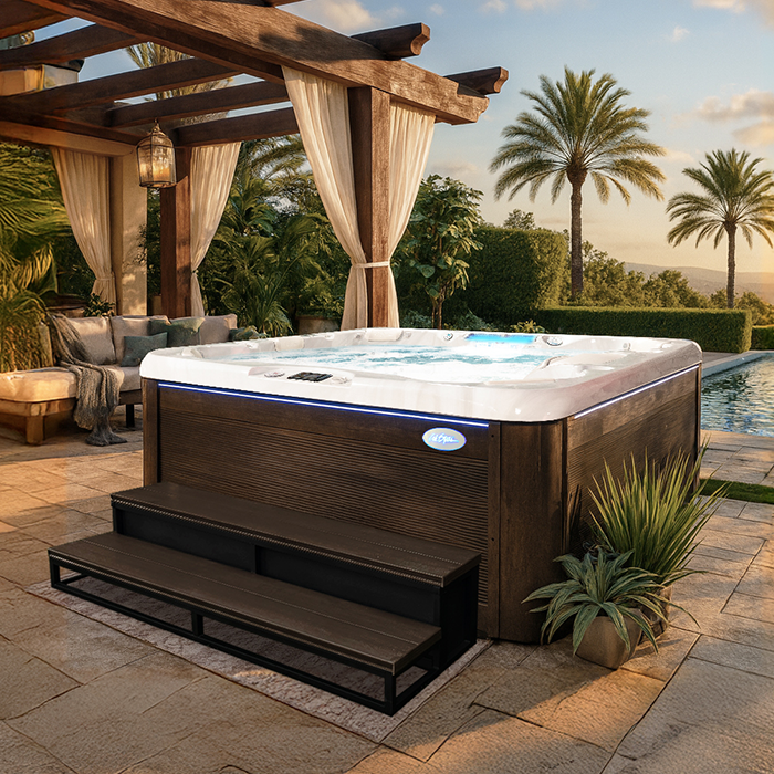 Outdoor hot tub on a patio under a pergola, surrounded by palms at sunset