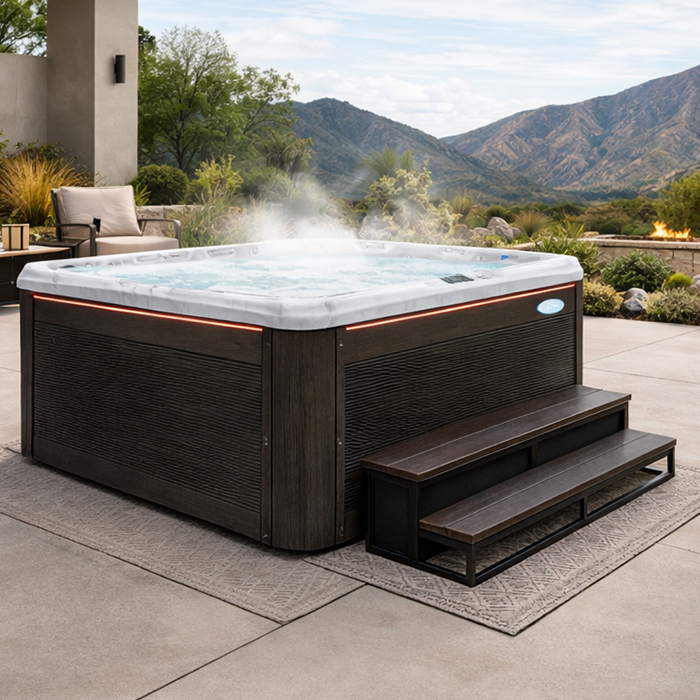 Modern hot tub on a patio with steam, steps, and mountain views