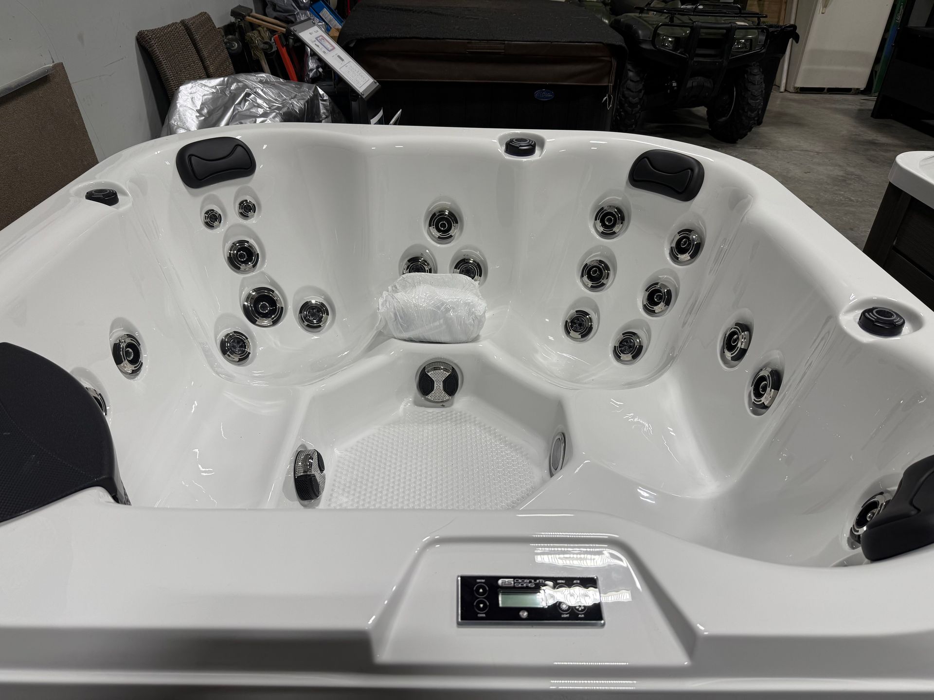White hot tub interior with multiple jets, control panel, and headrests.