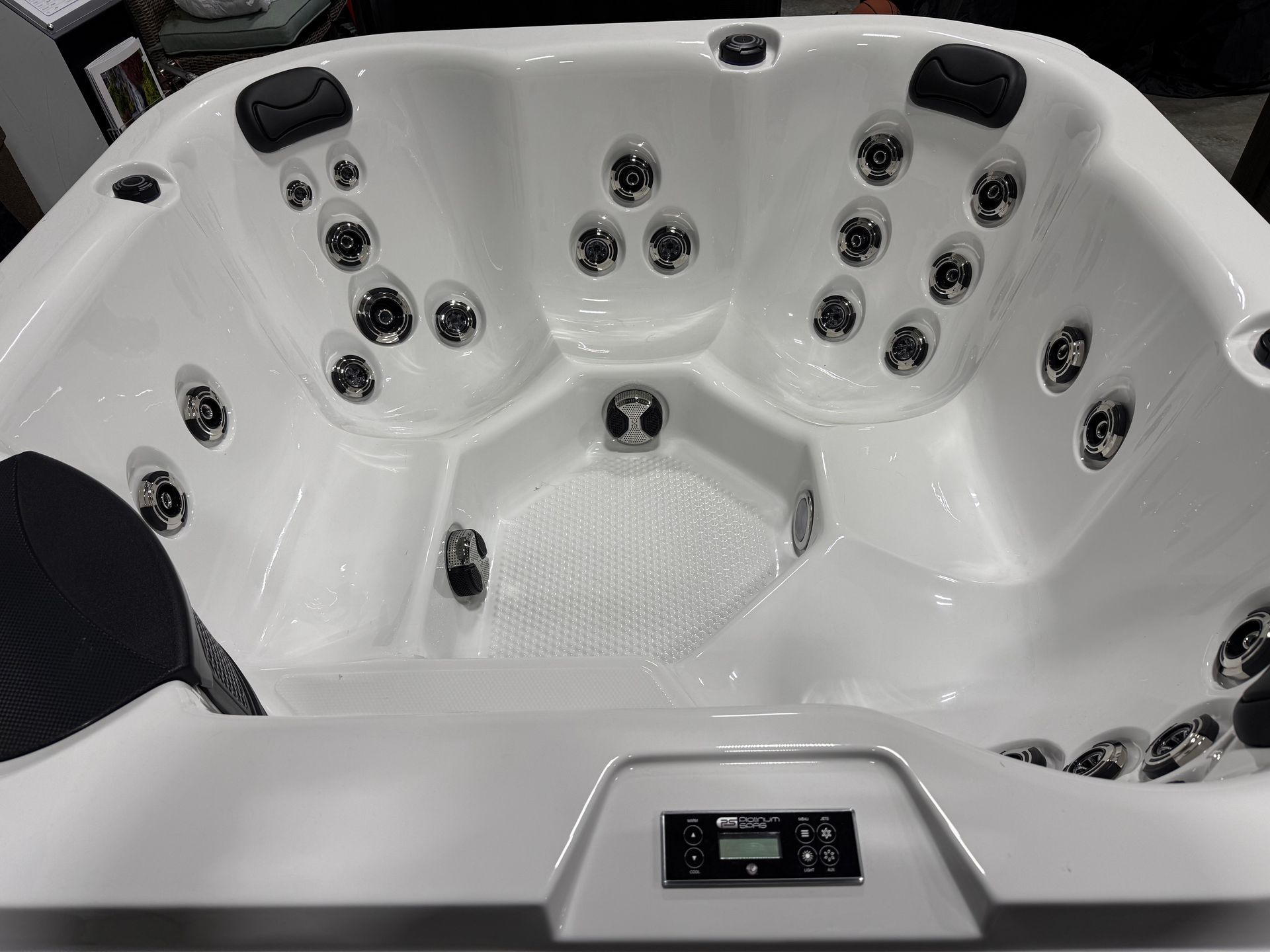 White hot tub interior with several jets and a control panel.
