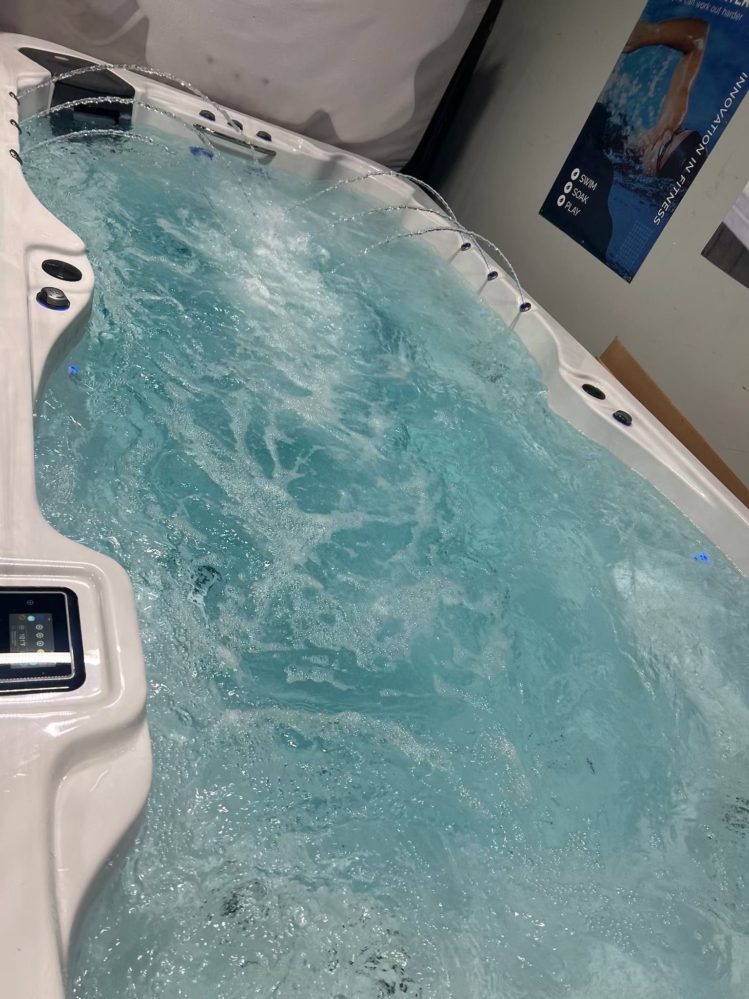 A rectangular swim spa with clear, bubbling water; white interior.