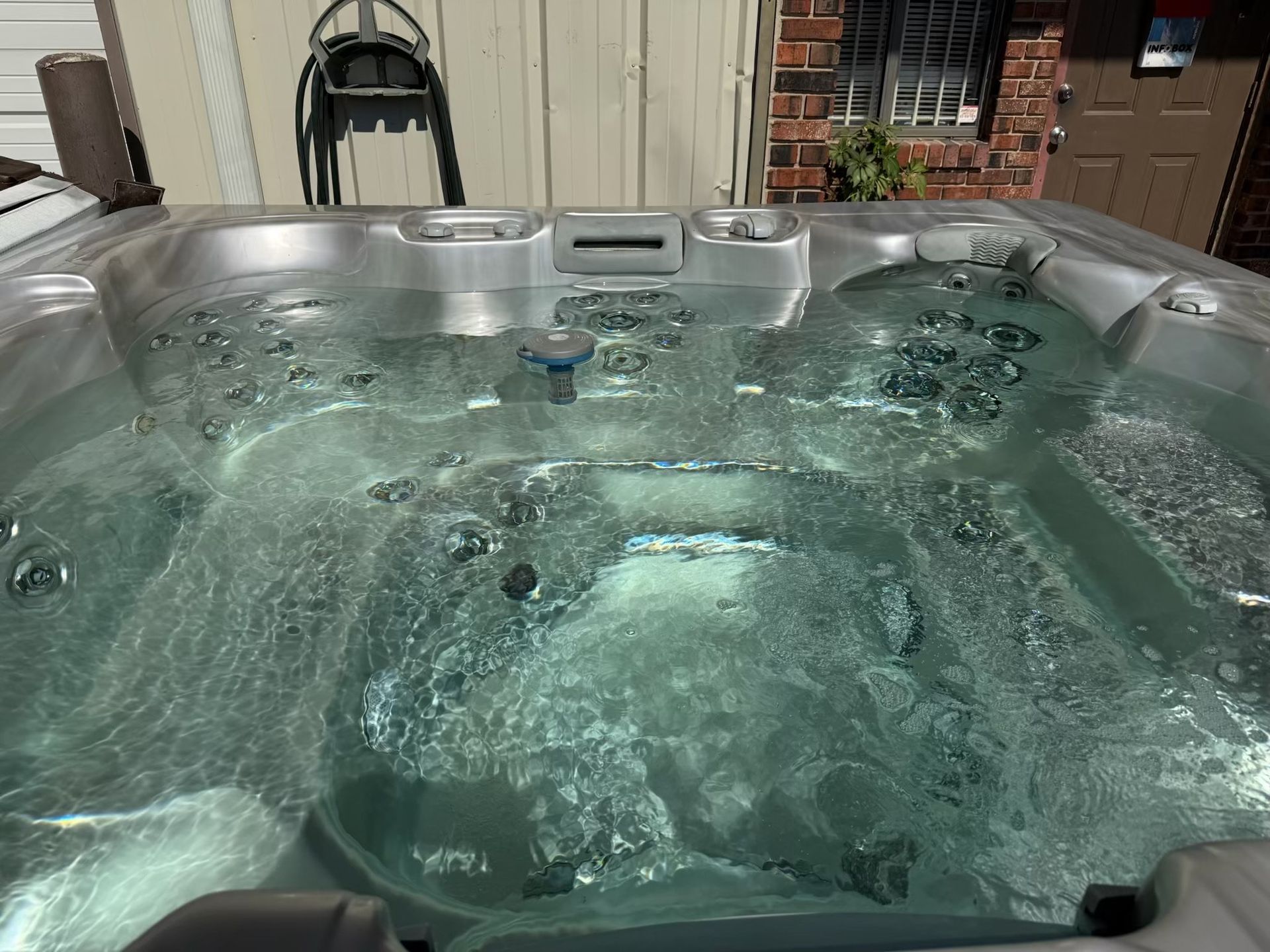 Hot tub filled with bubbly water, outdoors.