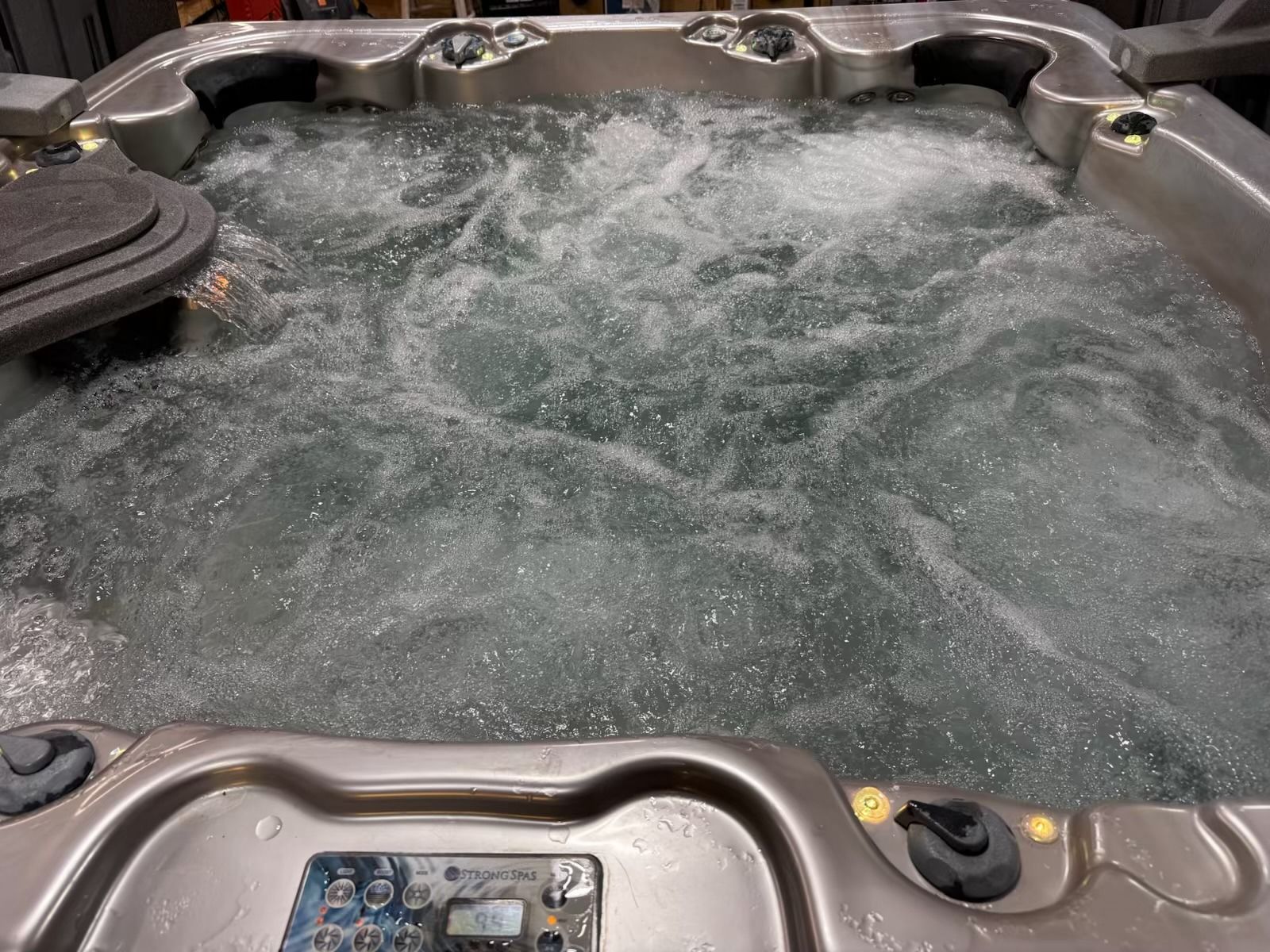 A bubbling hot tub with a control panel and water jets.