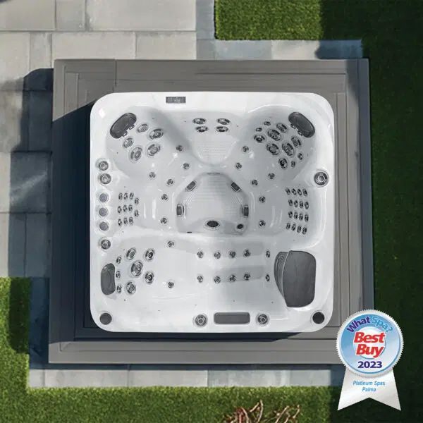 Top-down view of a white square hot tub with grey headrests set in a dark grey frame on a patio with a 2023 Best Buy award.