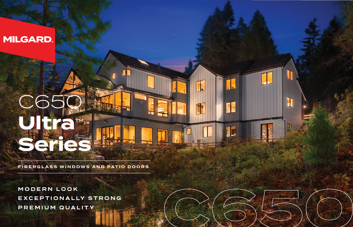 A large house with a lot of windows is surrounded by trees.