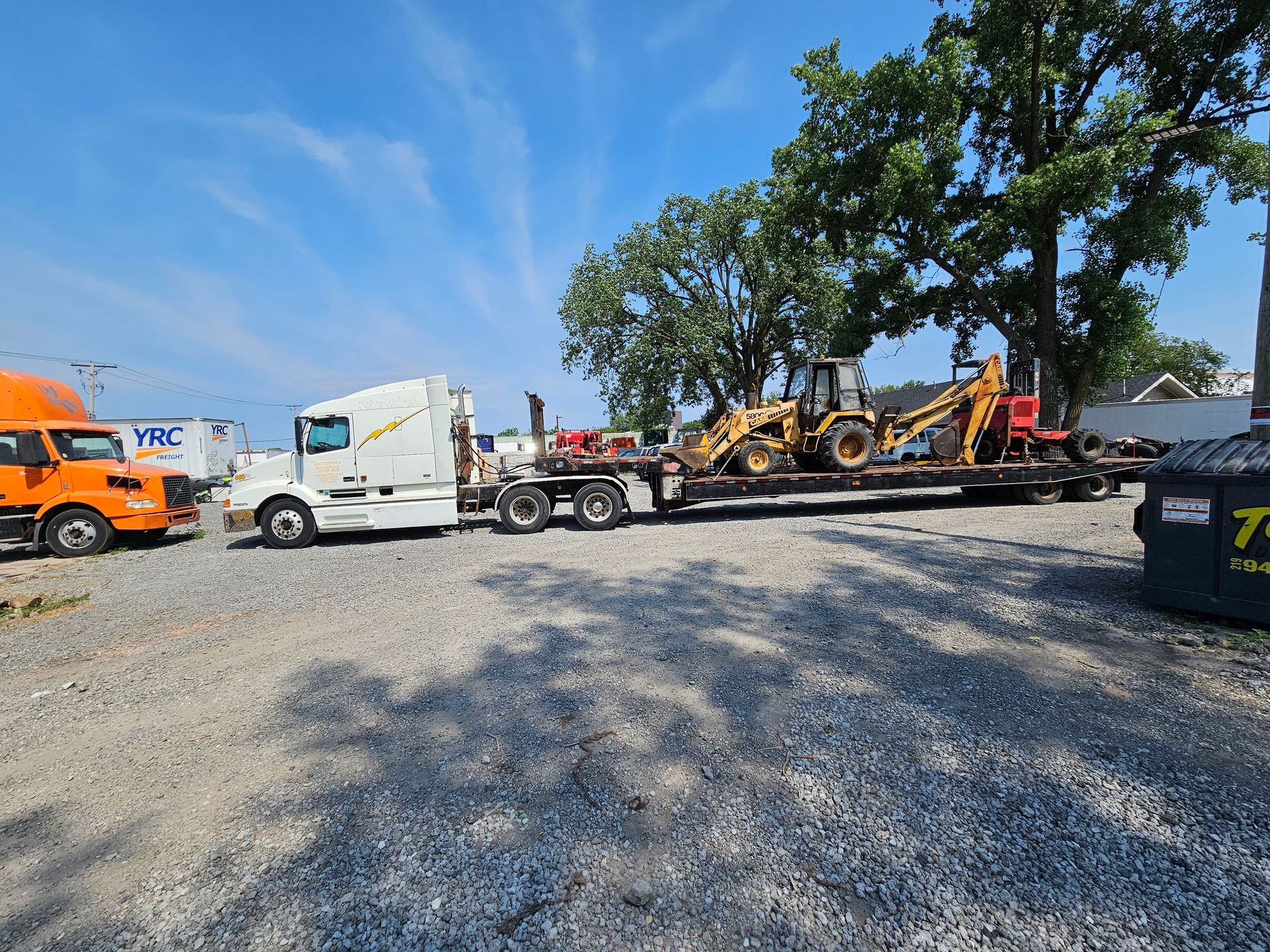 A semi truck is carrying a bulldozer on a flatbed trailer.