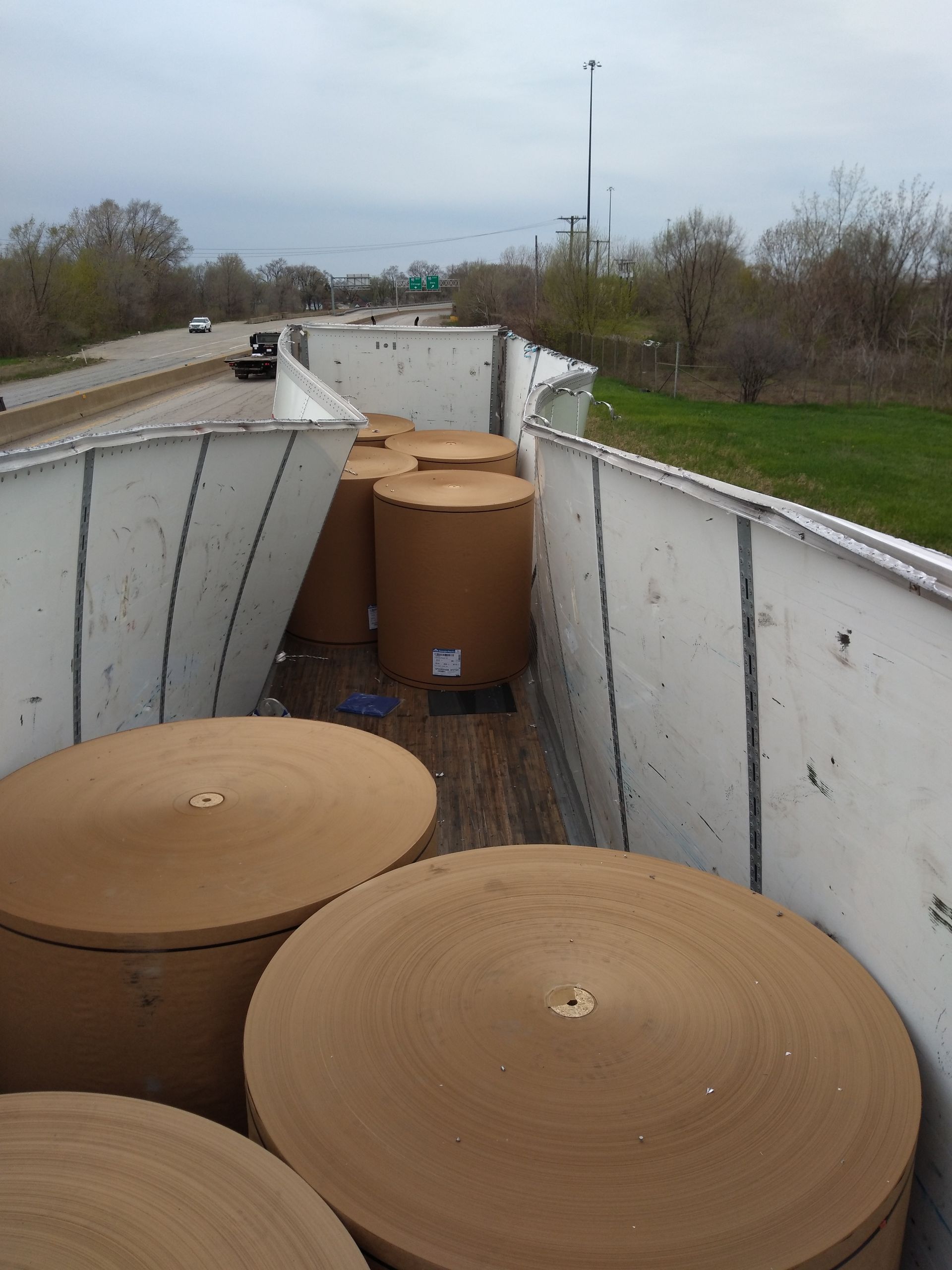 A bunch of cardboard rolls are sitting on the back of a truck