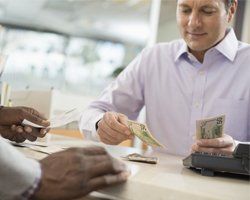 Man counting dollar bills on desk