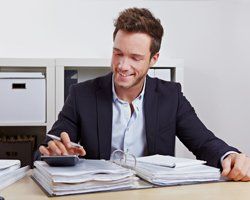 Man in suit using calculator on computing loans