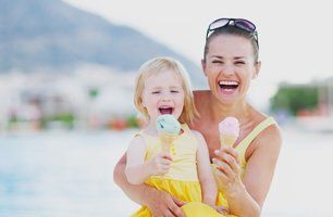 Woman and baby eating ice cream on beach
