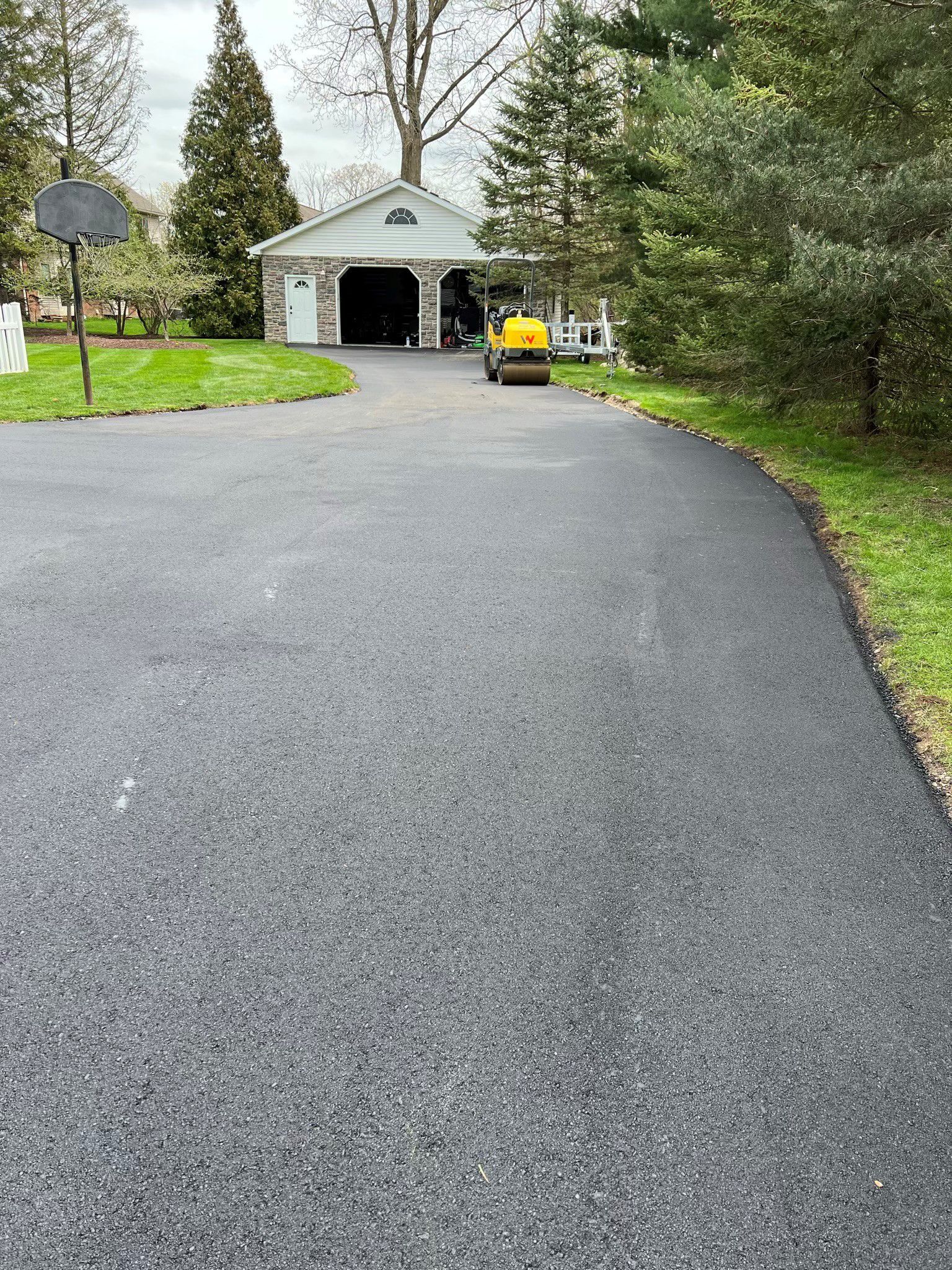 A car is parked in a driveway next to a garage.
