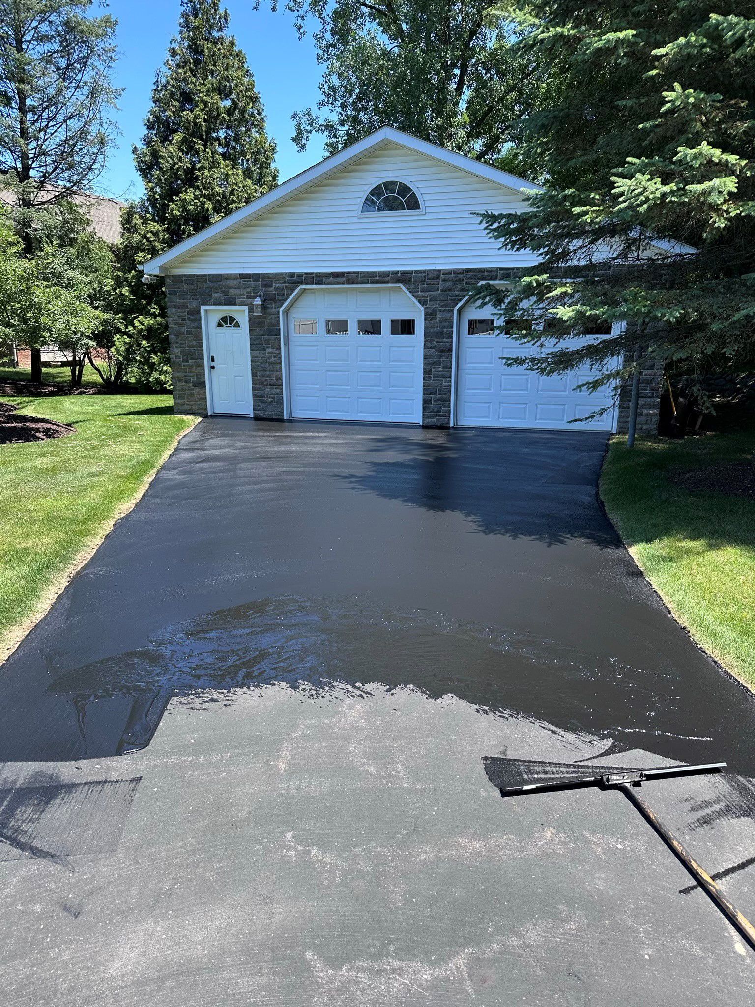 A driveway is being painted in front of a garage.