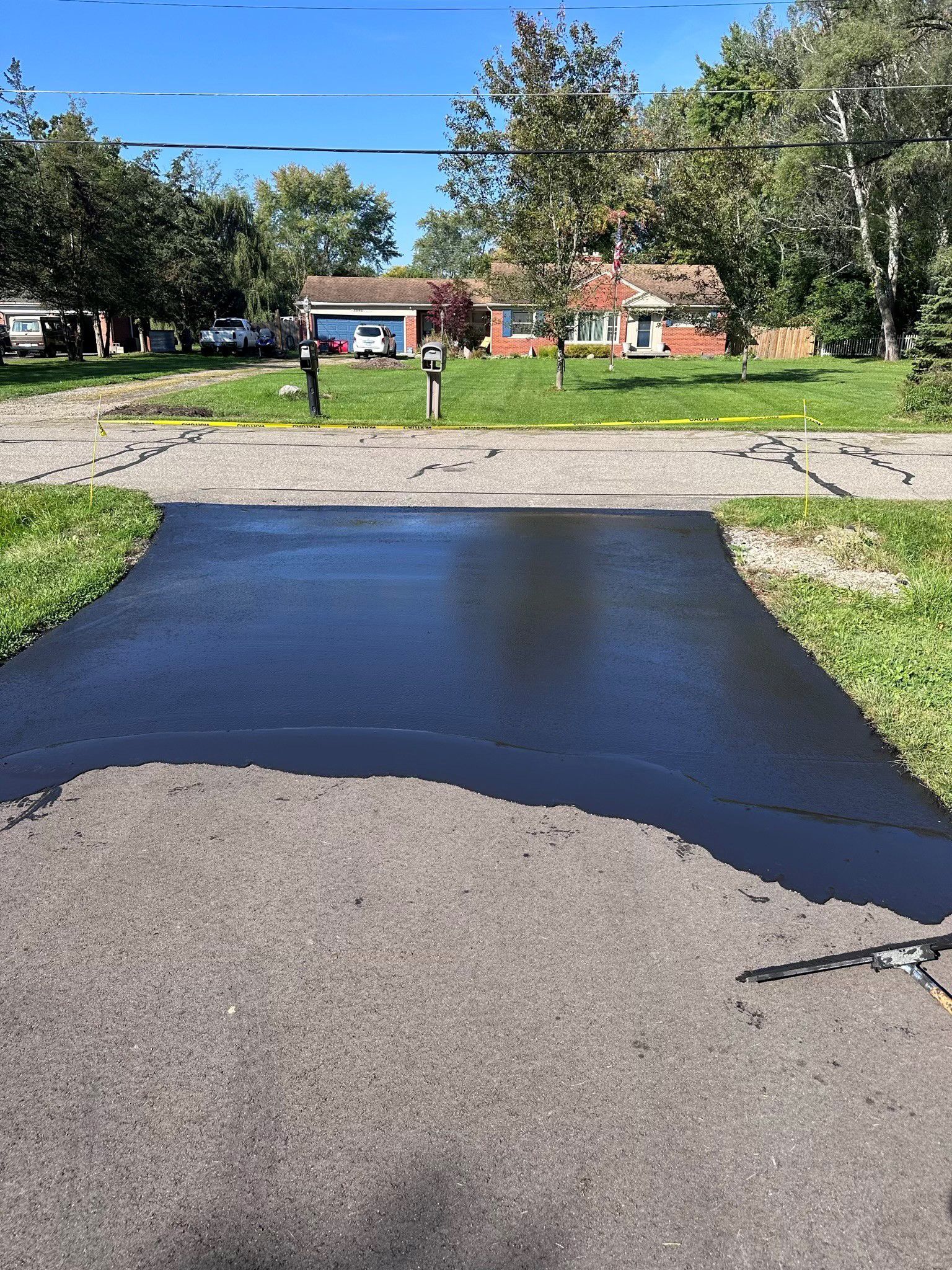 A newly paved driveway with a house in the background.