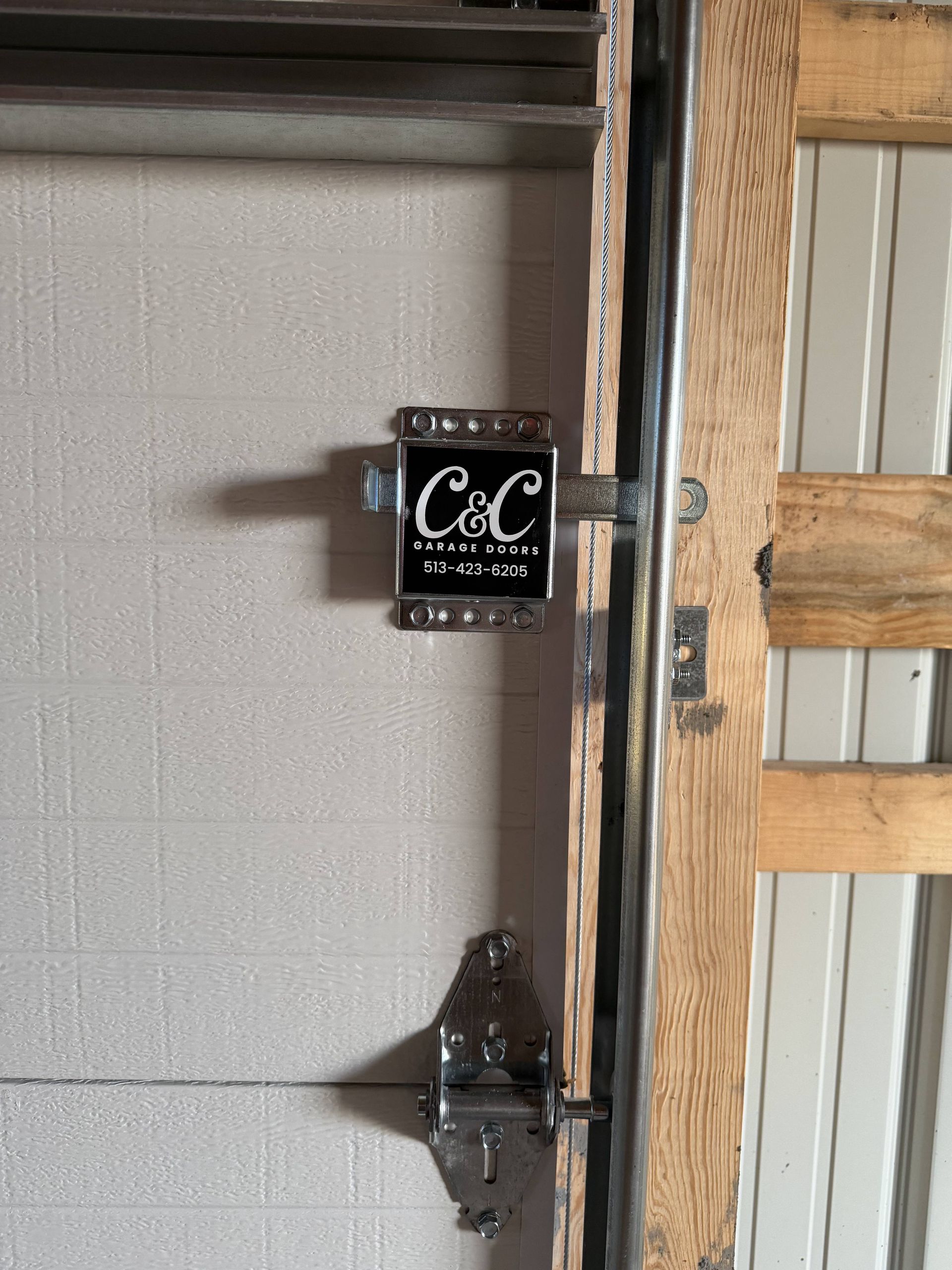 A garage door with a black and silver lock from C&C Garage Doors.