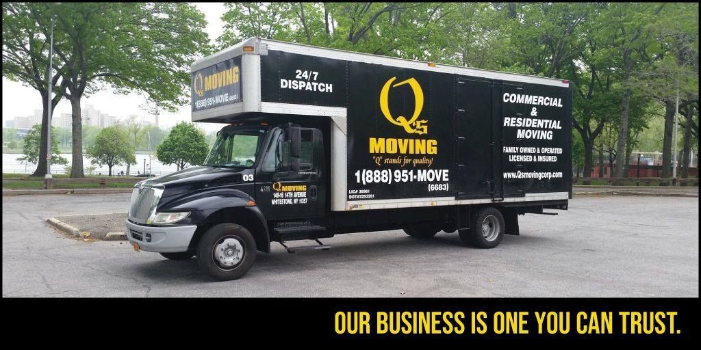 A black and white moving truck is parked in a parking lot