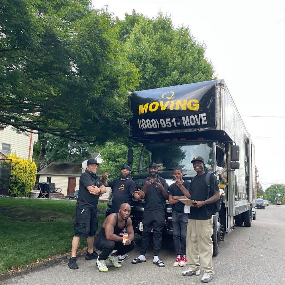 A group of men standing in front of a moving truck