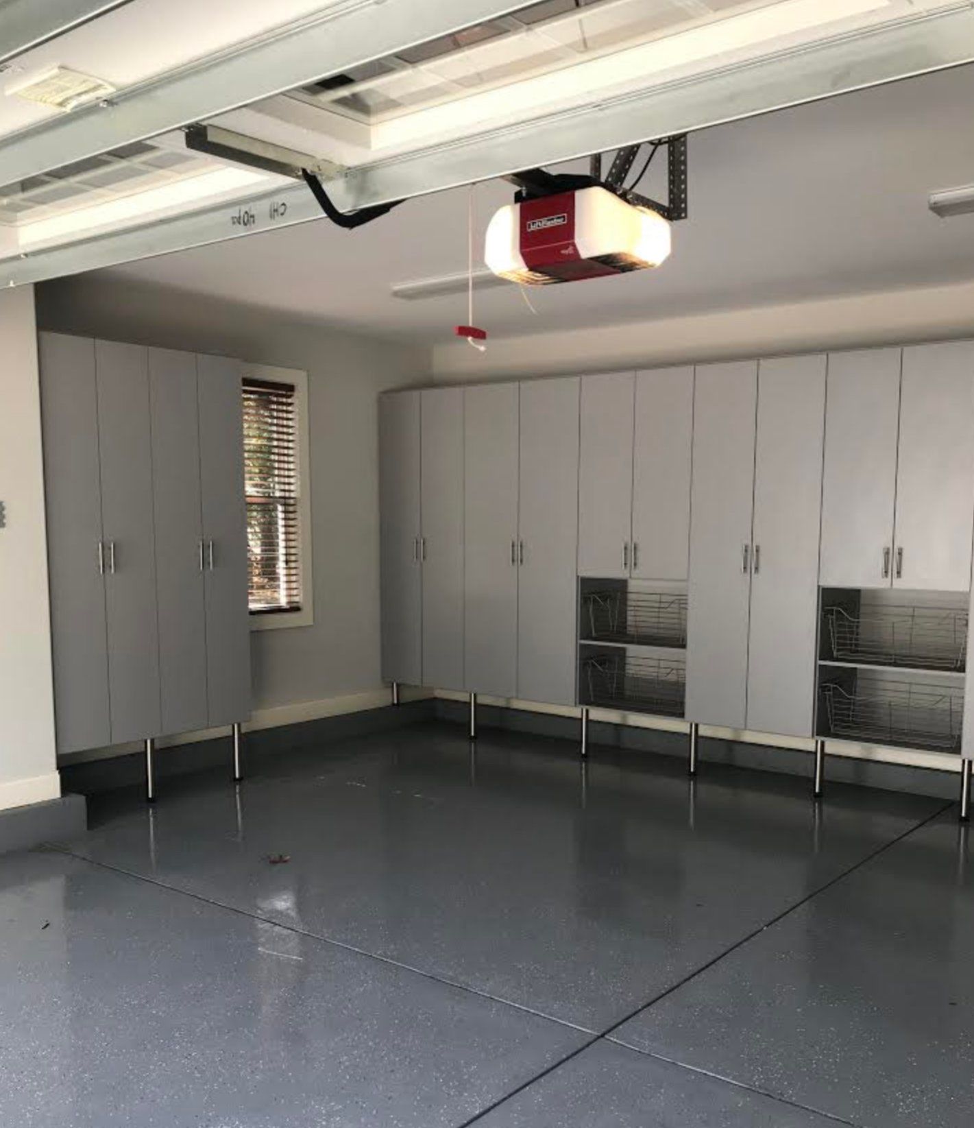 A garage with lots of cabinets and a garage door opener.