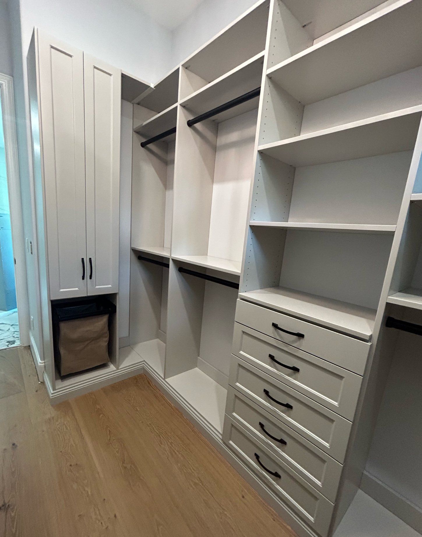 A walk in closet with lots of shelves and drawers.