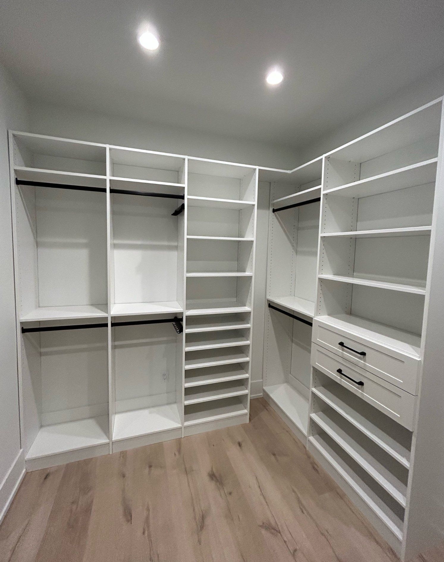A walk in closet with lots of shelves and drawers.