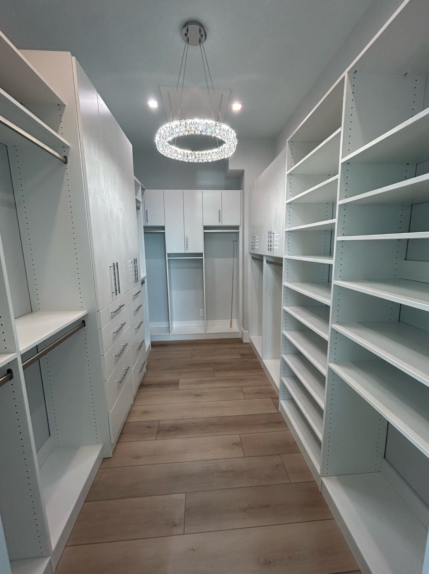 A walk in closet with lots of shelves and cabinets