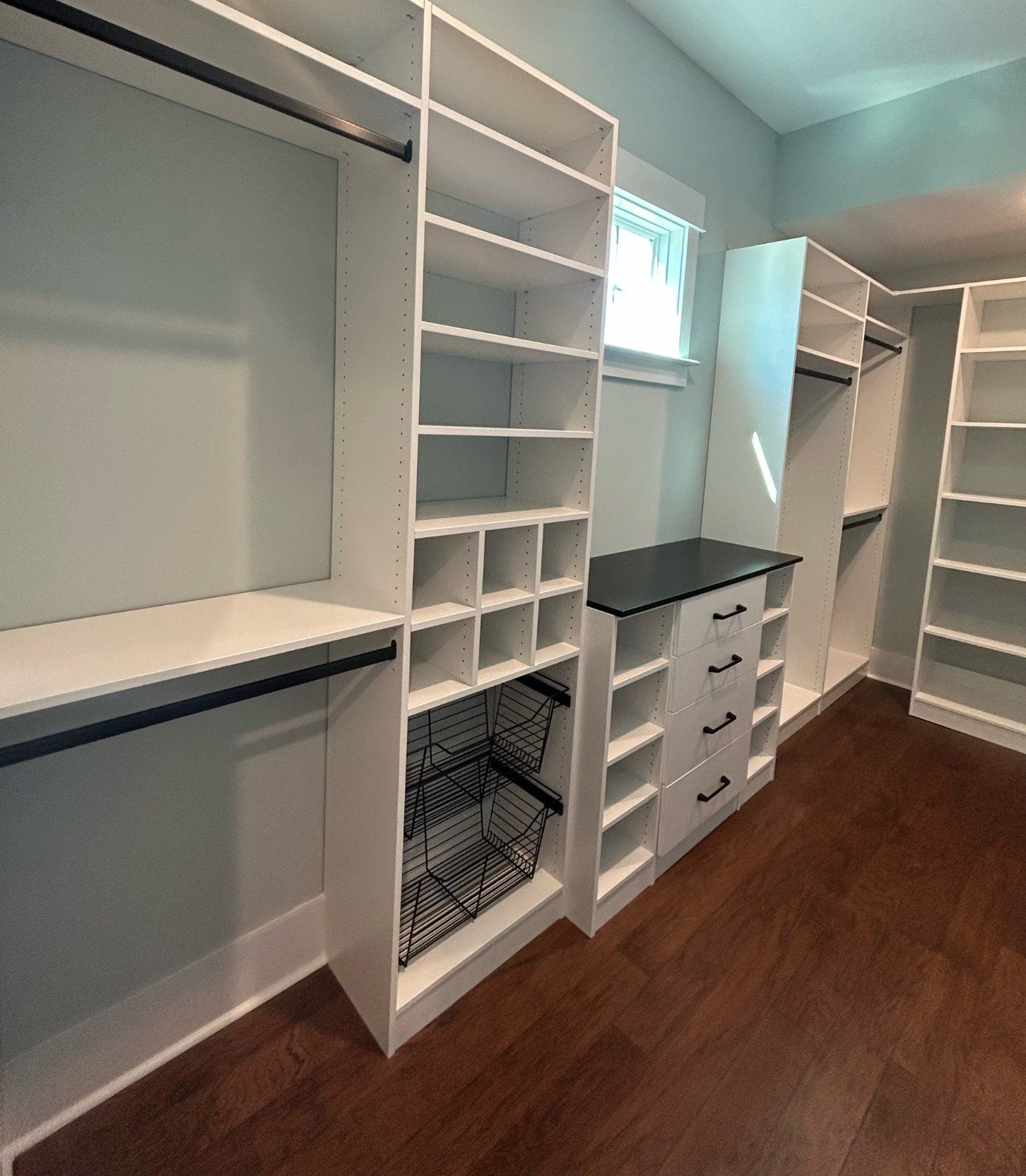 A walk in closet with lots of shelves and drawers.