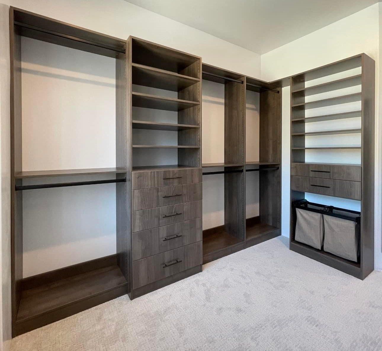 A walk in closet with lots of shelves and drawers.