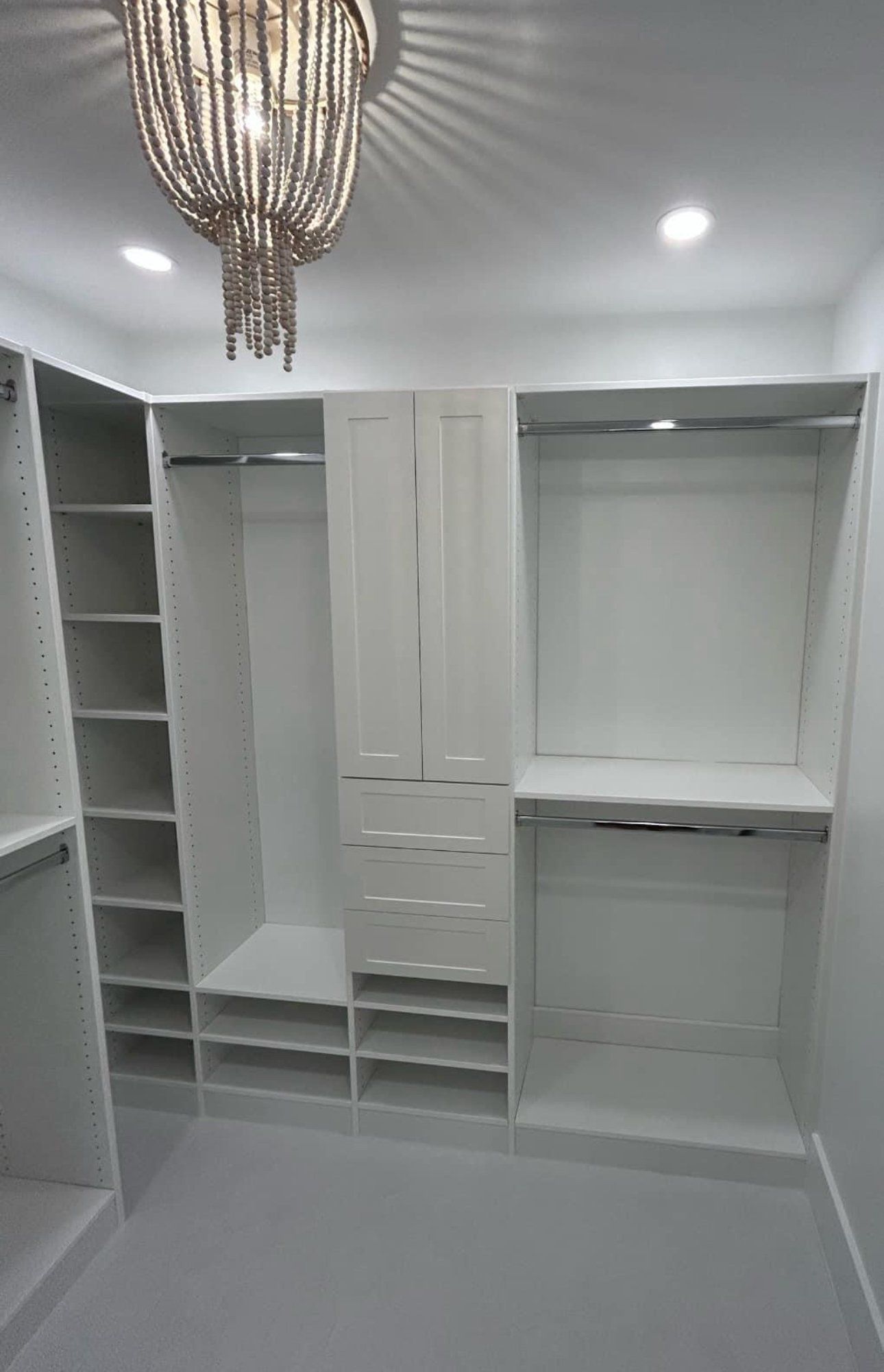 A walk in closet with a chandelier hanging from the ceiling.