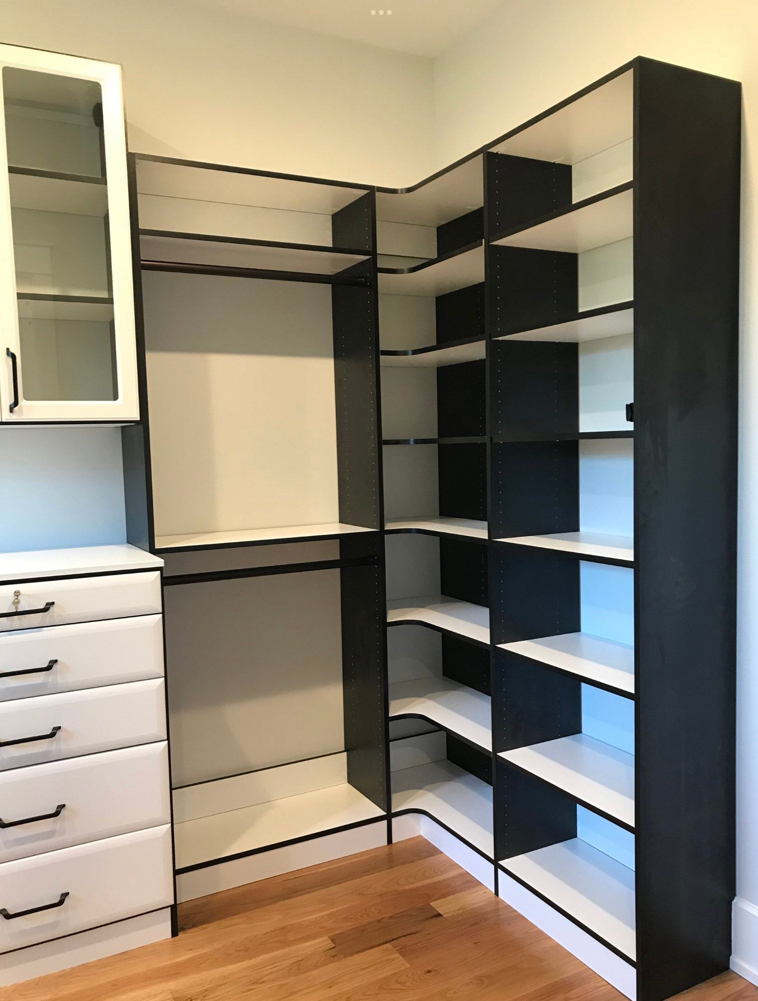 A walk in closet with lots of shelves and drawers