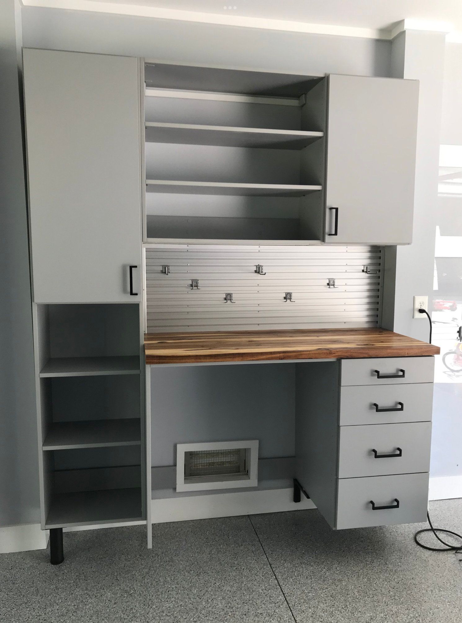 A desk with drawers and shelves in a garage