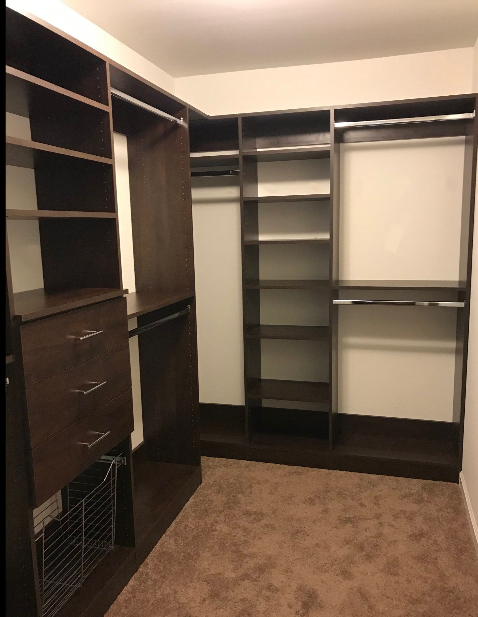 A walk in closet with lots of shelves and drawers