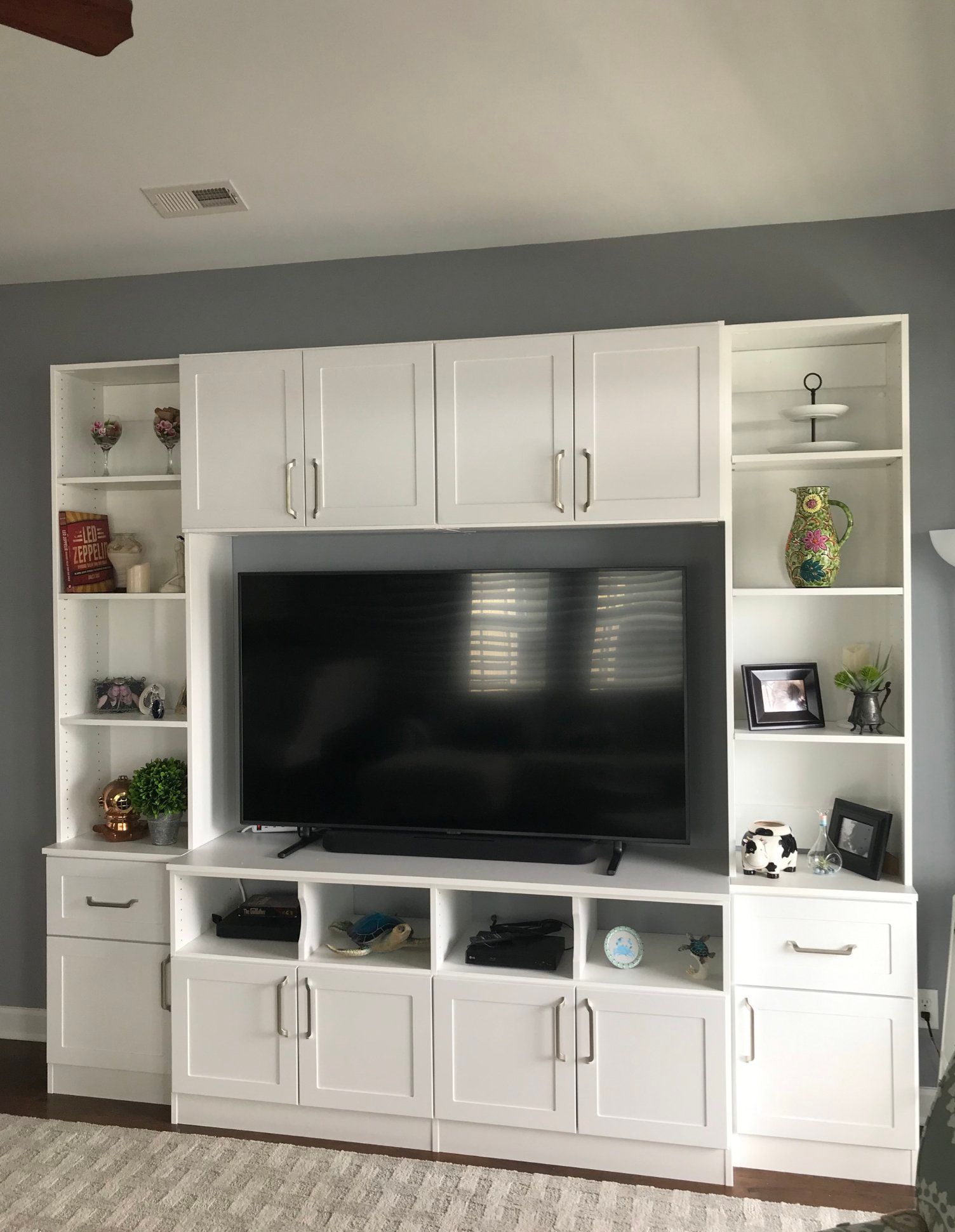 A large flat screen tv is sitting on top of a white entertainment center.